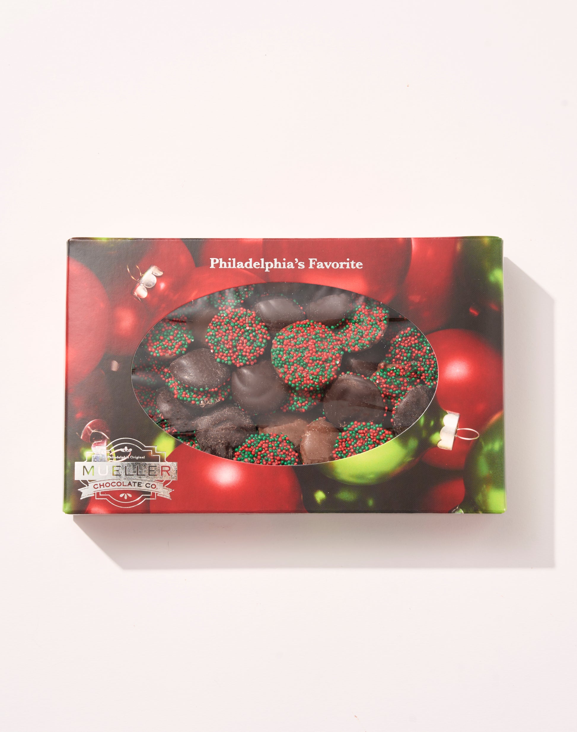 Assorted Chocolate Holiday Nonpareils Gift Box with festive red and green sprinkles inside holiday-themed packaging.