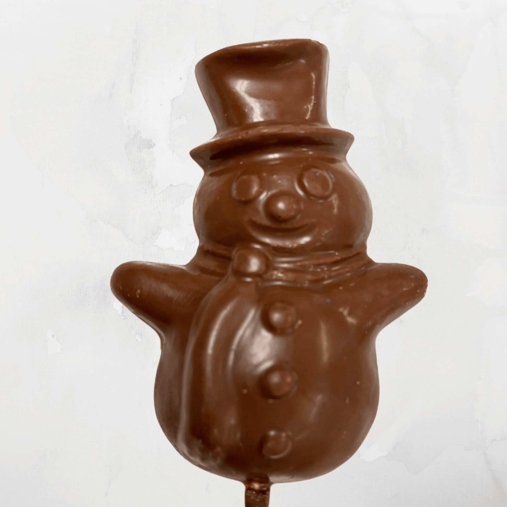 A festive milk chocolate snowman pop on a stick, perfect for holiday treats and gifts.